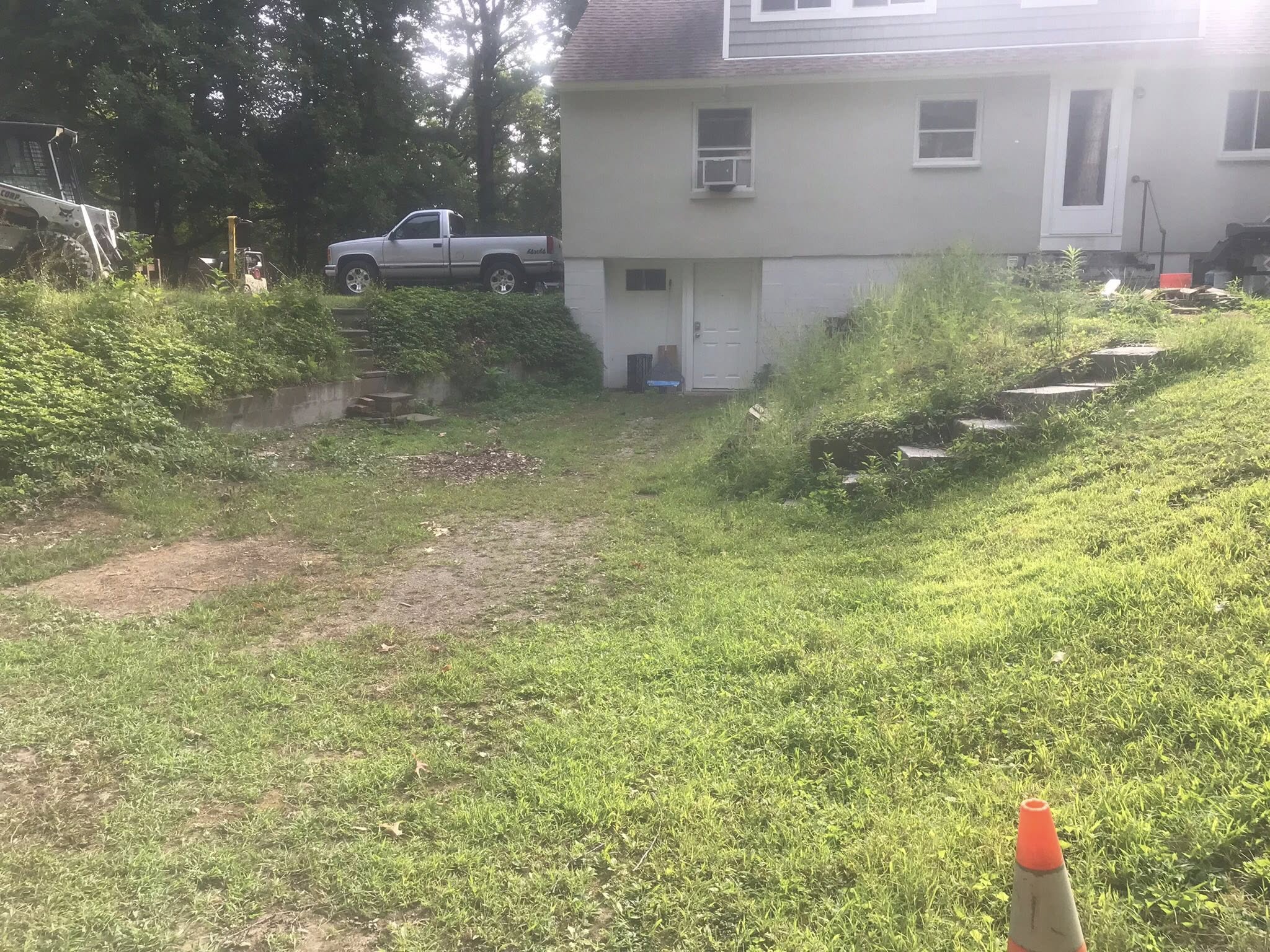 Overgrown hillside before retaining wall installation